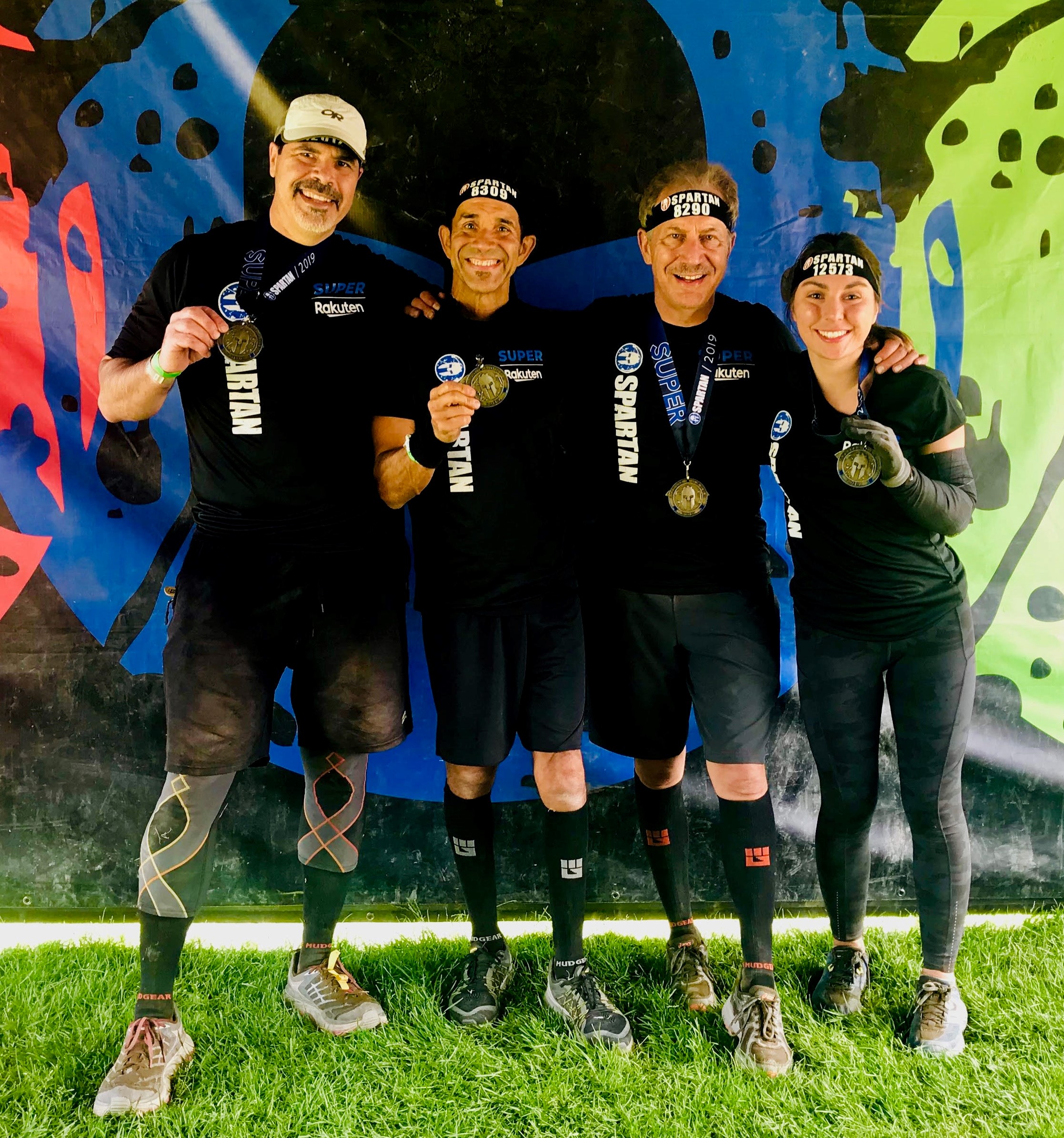 three group fitness friends and their personal trainer after a Spartan race