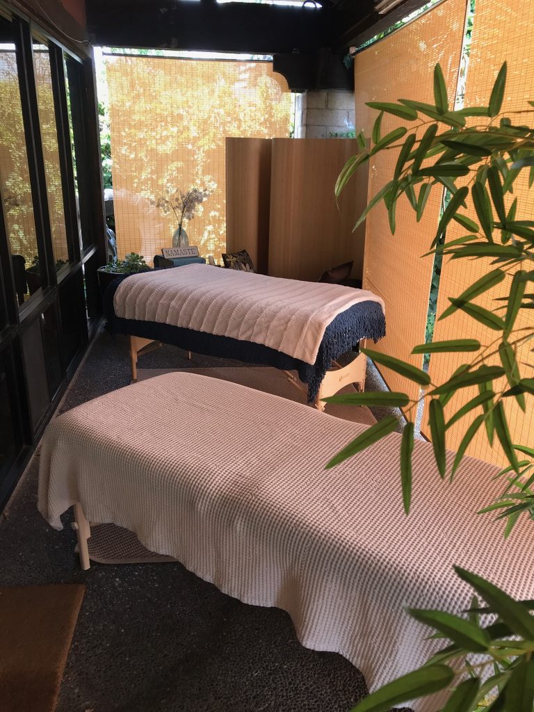 Two massage tables for massage therapy in a private outdoor setting.